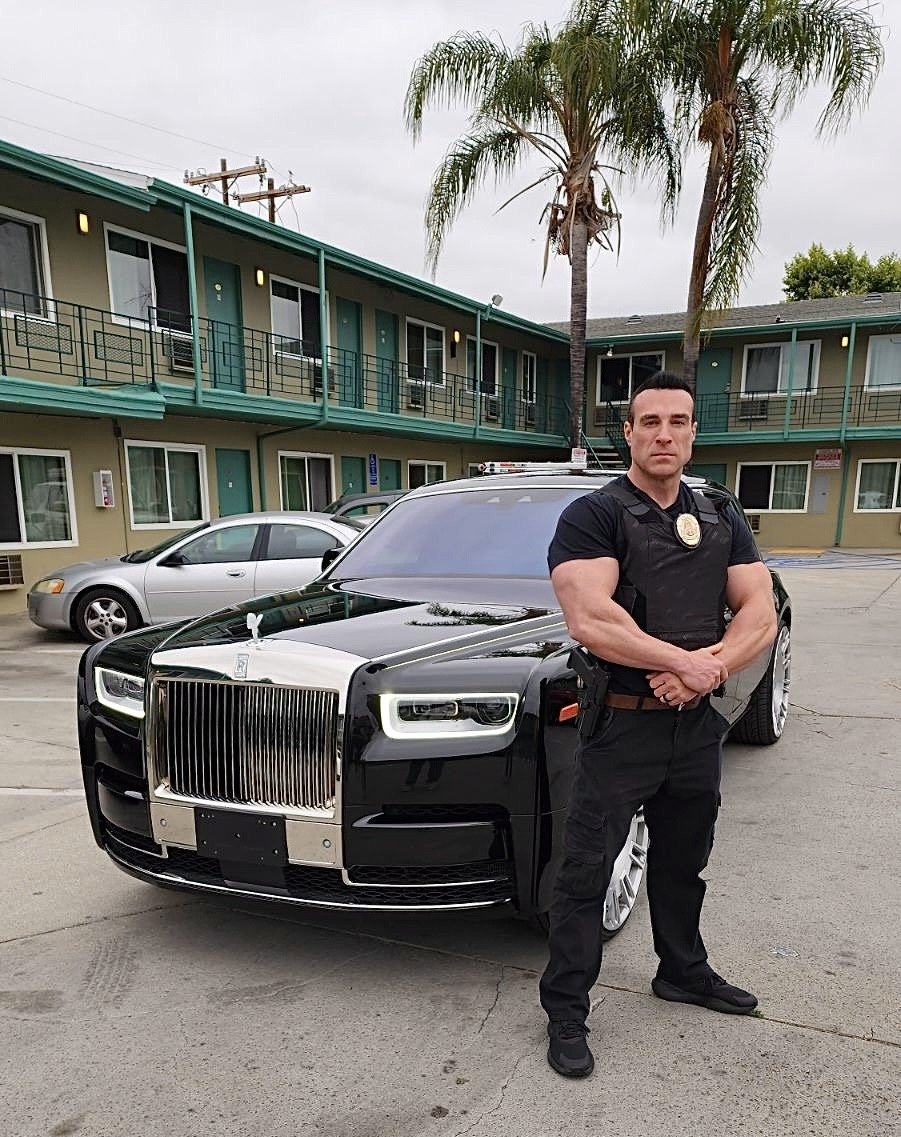 Security officer standing by Rolls Royce at residential property